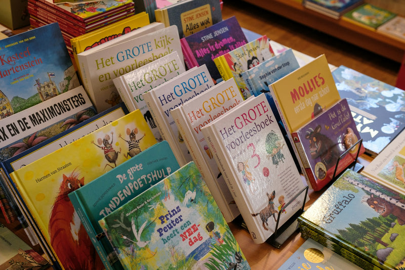 A stack of children's books piled on top of a table.