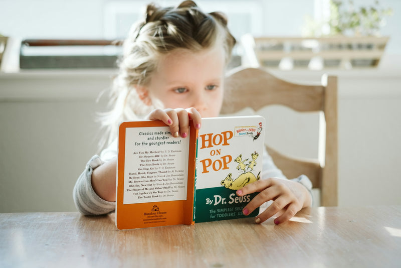 A girl sitting quietly with a book instead of a screen