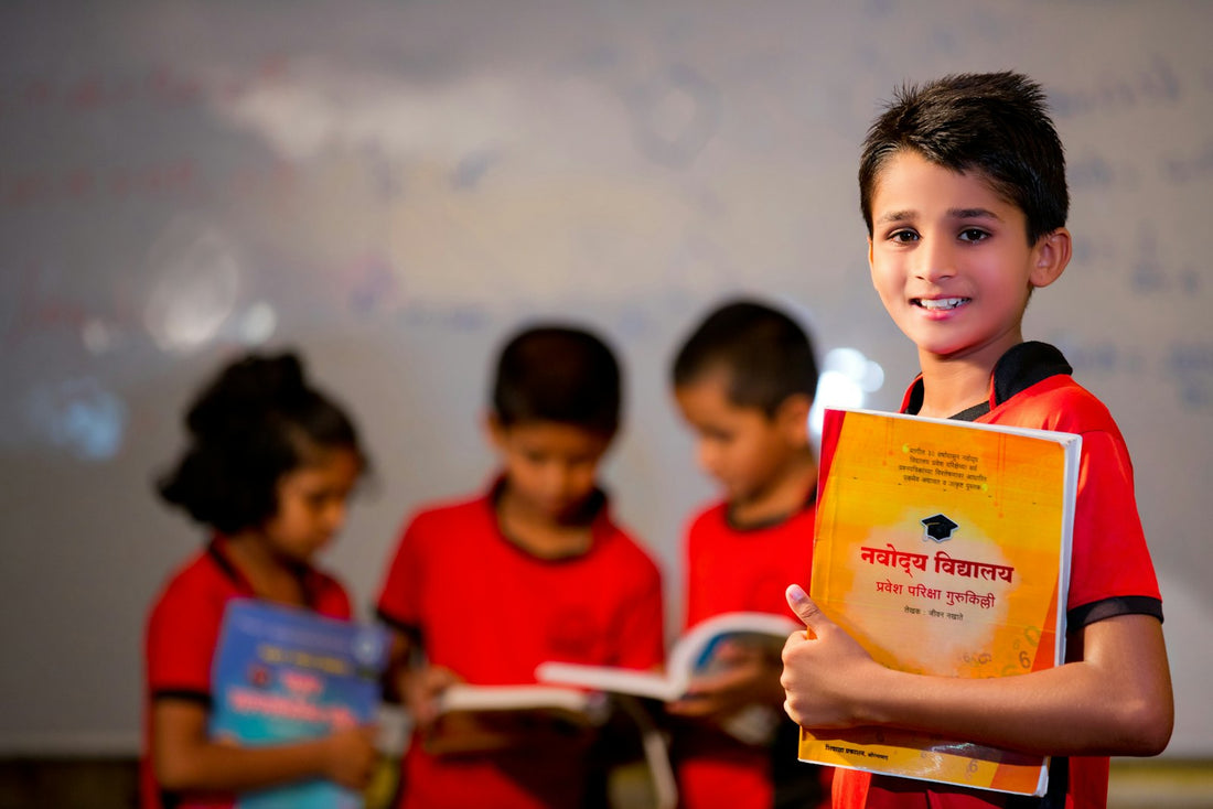 A boy in a red shirt holding and looking down at an open yellow book