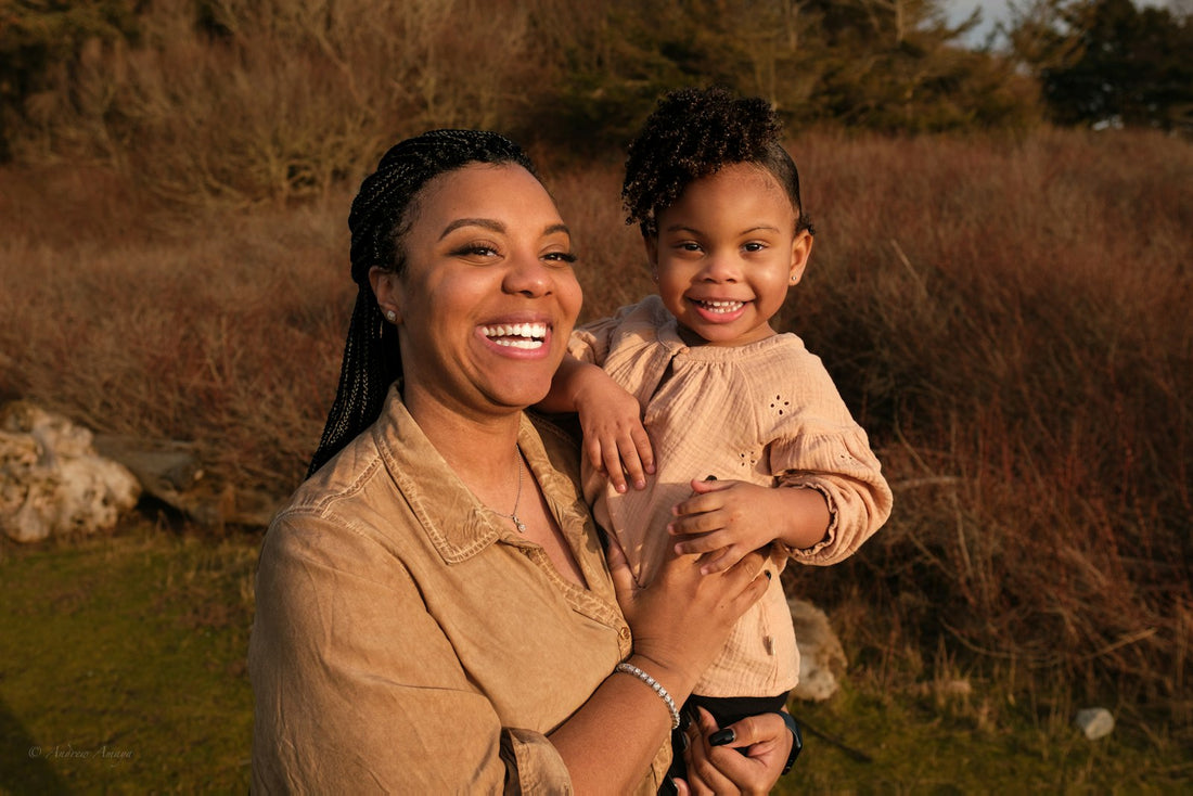 A woman holding a small child closely in her arms outdoors, a warm comforting embrace