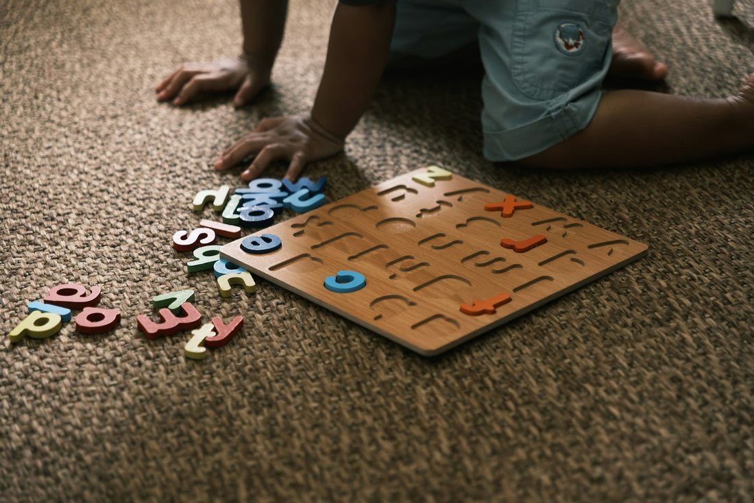 A young child playing with a wooden alphabet puzzle on the carpet
