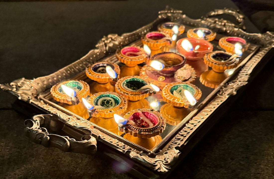 A tray of lit diyas glowing for a Diwali celebration