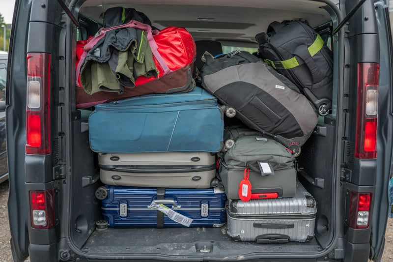 A car trunk packed full of suitcases and travel bags for a family trip
