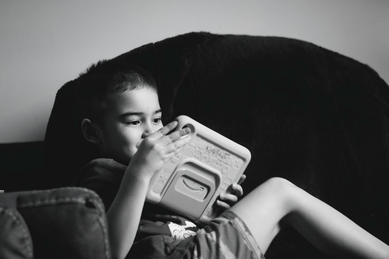 A young boy looking closely at a tablet screen
