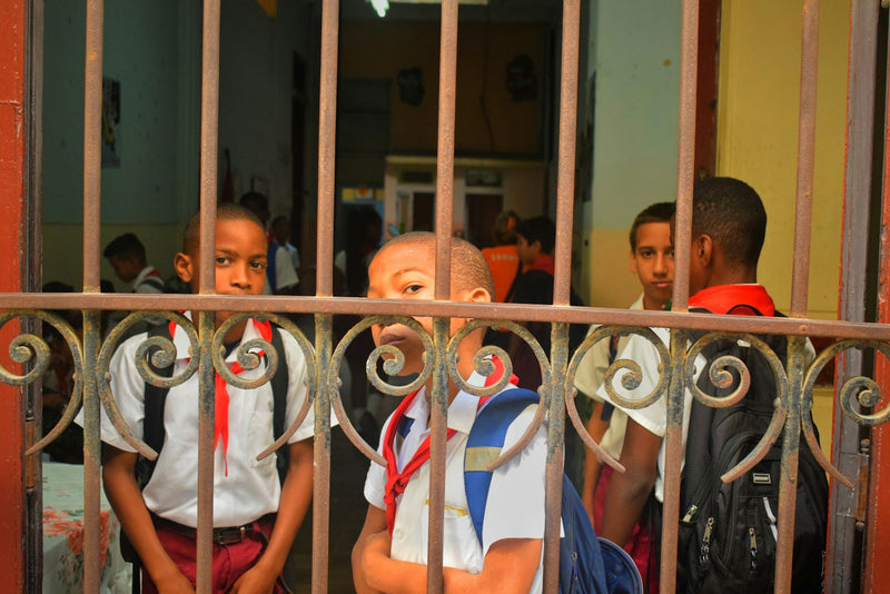Young schoolchildren in uniform standing together near their school's entrance